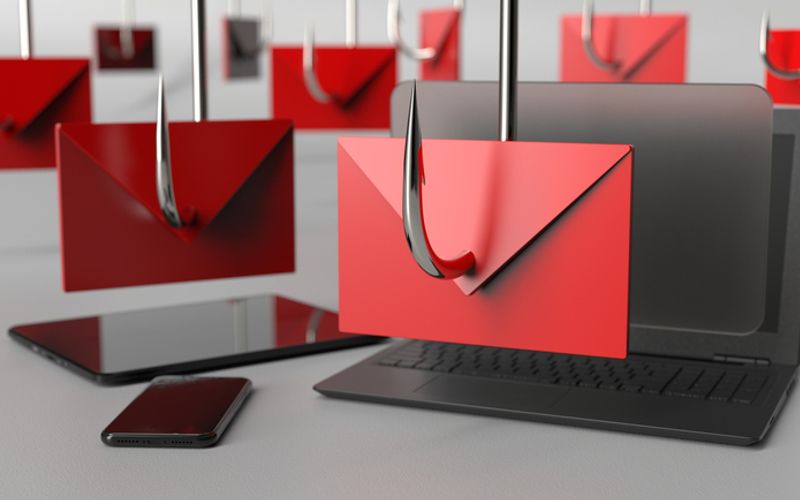 Phishing emails displayed on a laptop and smartphone